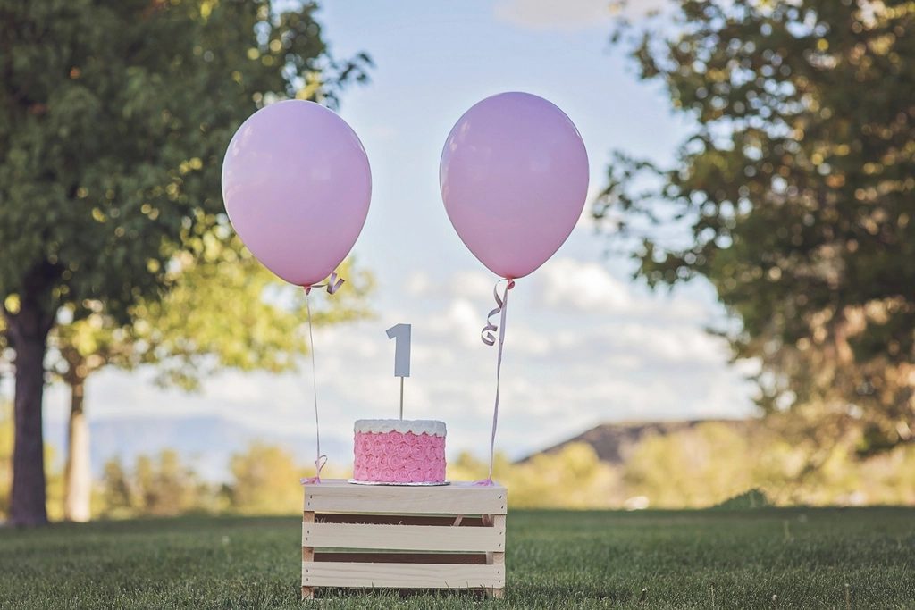 Balões lilás e bolo de primeiro aniversário