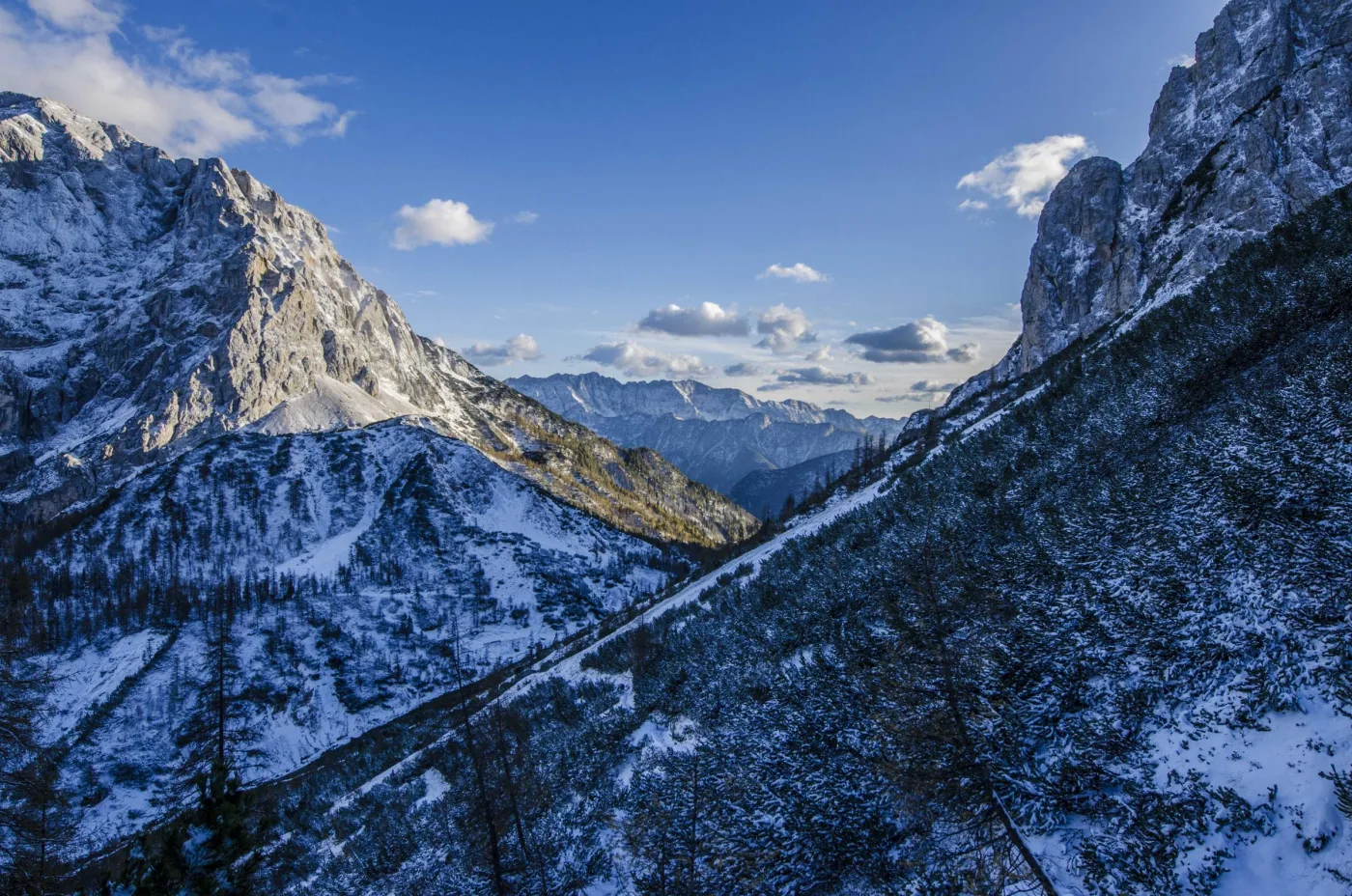 Picos nevados e encostas rochosas em dia de céu limpo